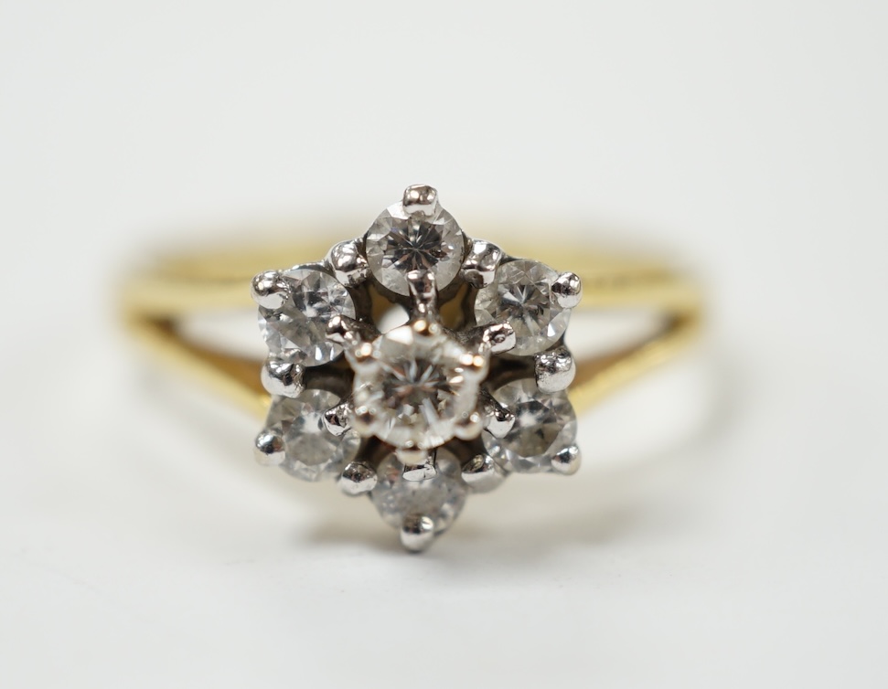A modern 18ct gold and seven stone diamond set flower head cluster ring, size M, gross weight 3.2 grams. Fair condition.